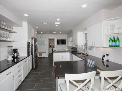 A crisp white and black kitchen with granite count