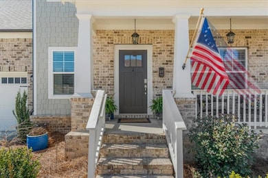 Entrance to property with a porch and brick siding