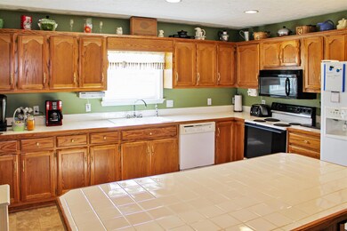 Large kitchen with lots of cabinets has extra seating