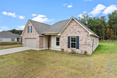 View of front of house featuring a front yard, brick siding, concrete driveway, a shingled roof, and board and batten siding