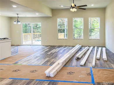 Living room with recessed lighting, LVP finished floors, and a chandelier