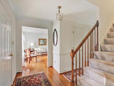 Enter through the lovely foyer with crown molding, chair rail and hardwood floors