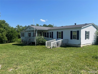 Back of property with a yard and covered porch