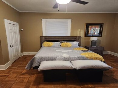Bedroom with crown molding, a ceiling fan, and bas