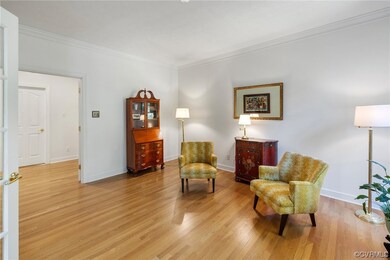 Sitting room with crown molding and hardwood floor