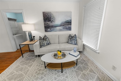 Living area with stacked washer / drying machine and wood finished floors