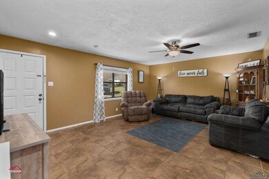 Living area with visible vents, baseboards, a text