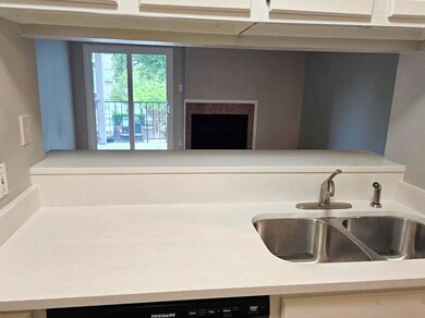 Kitchen view of a sink and light stone countertops