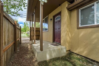 Doorway to property featuring stucco siding and fence