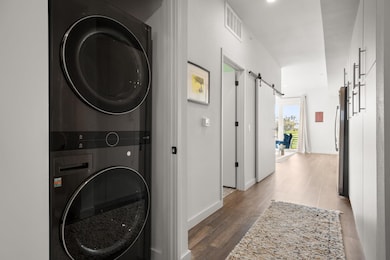 Washroom with stacked washer / dryer, a barn door