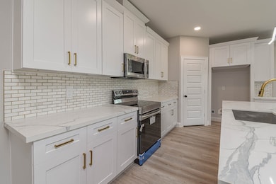 This modern kitchen features sleek white cabinetry