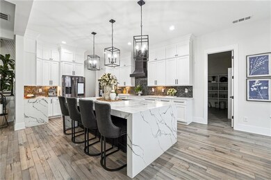 Kitchen with decorative light fixtures, white cabi