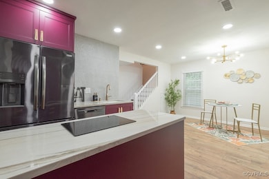 Kitchen with fridge with ice dispenser, light wood-style floors, recessed lighting, black electric cooktop, and stainless steel dishwasher