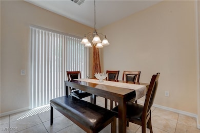Dining area featuring baseboards, light tile patte