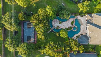 Ariel view shows the vast backyard layout complete with lazy river, basketball/tennis/pickleball court while still providing plenty of yard space for your personal family needs.