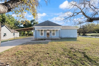 View of front of home with a front yard, concrete driveway, and a porch