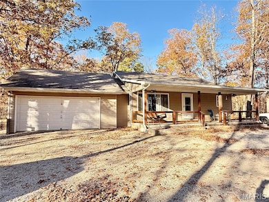 Rear view of house with a porch, driveway, a garage, and a shingled roof