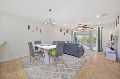 Dining area with ceiling fan, recessed lighting, light tile patterned floors, and a chandelier