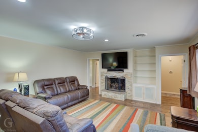 Stone gas log fireplace. Built-in bookshelves