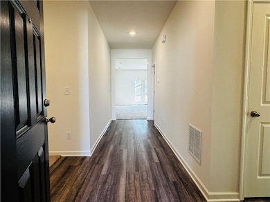 Hallway featuring dark wood-type flooring