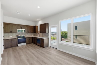 Kitchen with appliances with stainless steel finishes, backsplash, dark brown cabinetry, recessed lighting, and light wood-style floors