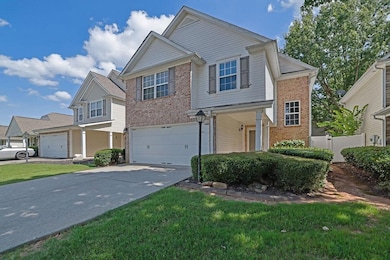 View of front of property featuring brick siding, driveway, and a garage