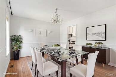 Dining space with a chandelier and light wood-styl