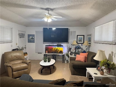 Living area with ceiling fan and a textured ceiling