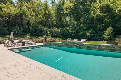 Step in to your refreshing pool while enjoying complete privacy provided by mature trees and shrubberies.  The new stacked stone wall offers a fire pit & pool fountains. Travertine tile hardscaping surrounds the area for year-round living. 
