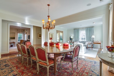 Dining space featuring crown molding, wood finished floors, plenty of natural light, and a chandelier