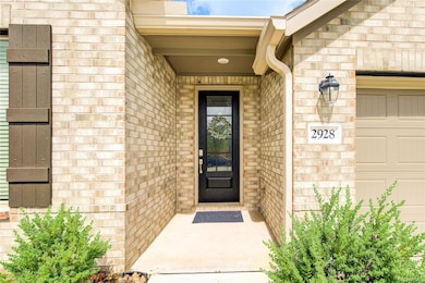 Doorway to property featuring a garage and brick 