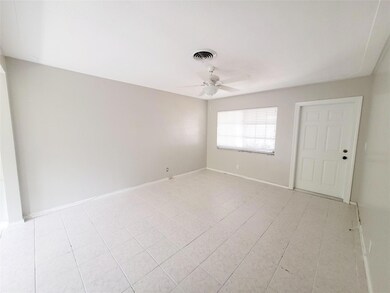 Spacious living room with tile flooring and overhe