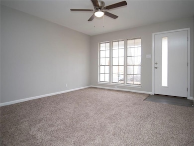 Carpeted spare room featuring baseboards and ceil