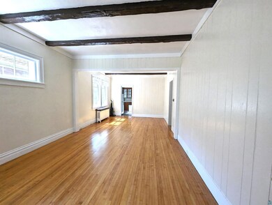 Unfurnished room with radiator heating unit, beame