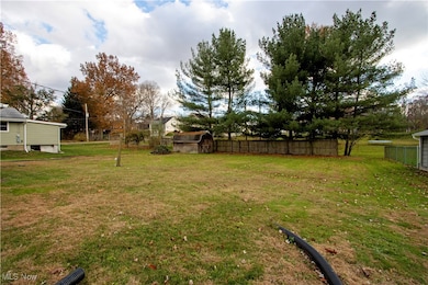 Fenced backyard featuring a shed