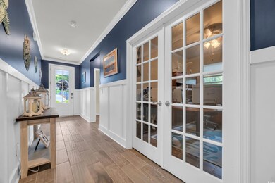 Doorway to outside featuring crown molding, wainsc