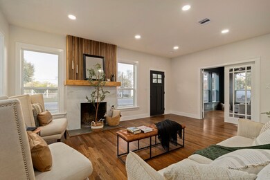 This spacious family room seamlessly connects to the formal living area (or potential home office) located just beyond the French doors.