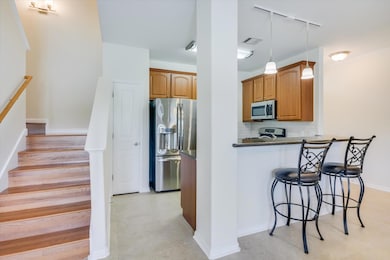 Kitchen with track lighting, appliances with stai