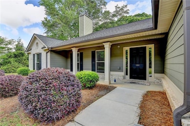 Doorway to property featuring a porch, roof with s