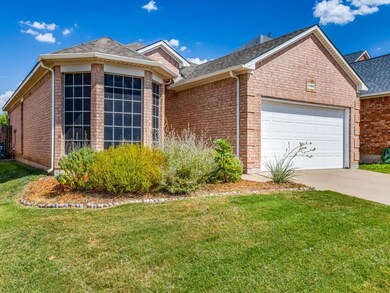 Single story home with a garage and a front lawn