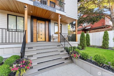 Covered front porch is just one of four decks (3 covered) where you can relax outside. 8' custom front door is framed with imported birch panels.