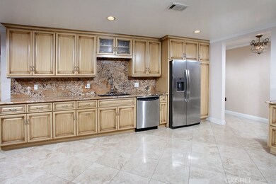 The chef in the family is going to truly appreciate the expansive remodeled kitchen with its sparkling picture window,  recessed lighting, newer modern antique finished cabinetry, pantry, dual basin undermount  sink with pull-down faucet, granite cou