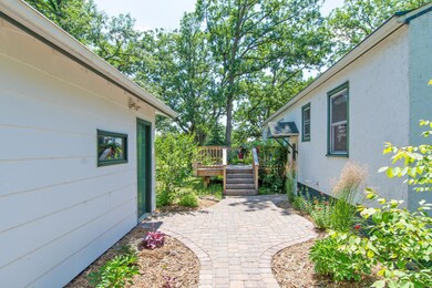 What a beautiful and welcoming paver patio between the garage and house with east deck access as well.
