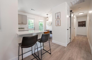 Kitchen with a breakfast bar, gray cabinets, ligh