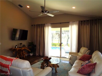 Living room with wood-type flooring, vaulted ceili