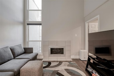 Living room featuring baseboards, a fireplace, wo
