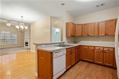 Kitchen with light countertops, a sink, light wood