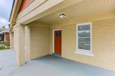 View of exterior entry with a patio and brick siding