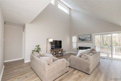 Living room featuring high vaulted ceiling, a fire
