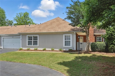 Ranch-style house featuring an attached garage, driveway, a front yard, and a shingled roof